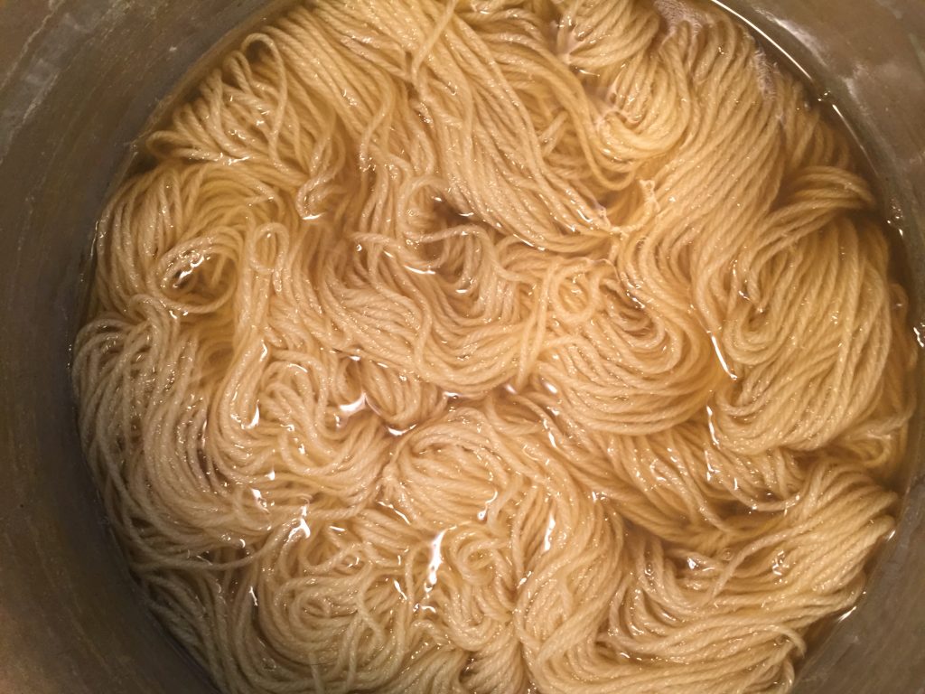 Soaking yarn to prepare to dye with dandelions